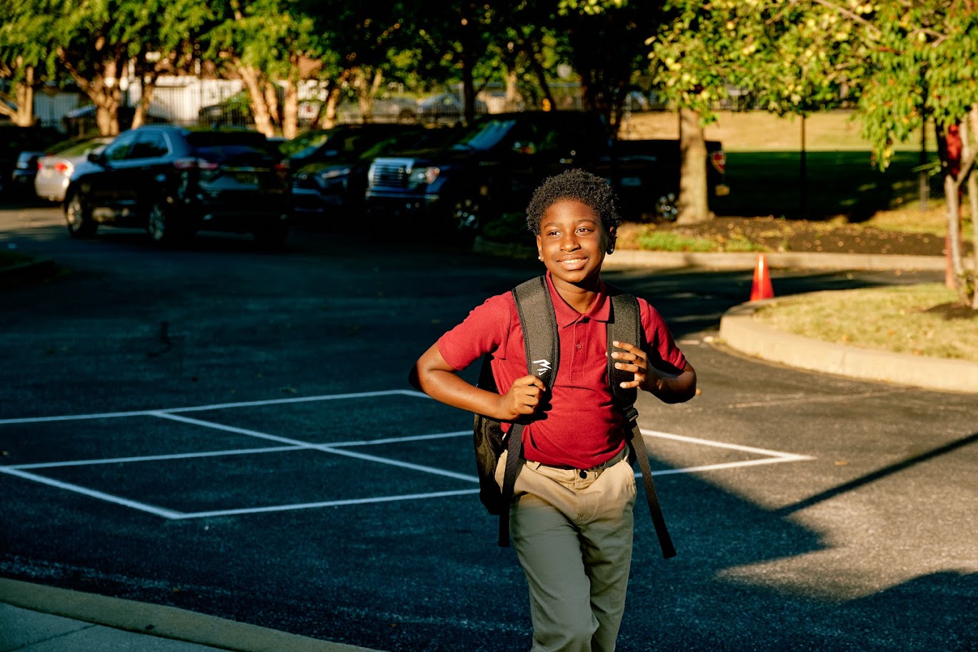 a student walking into school with their bookbag