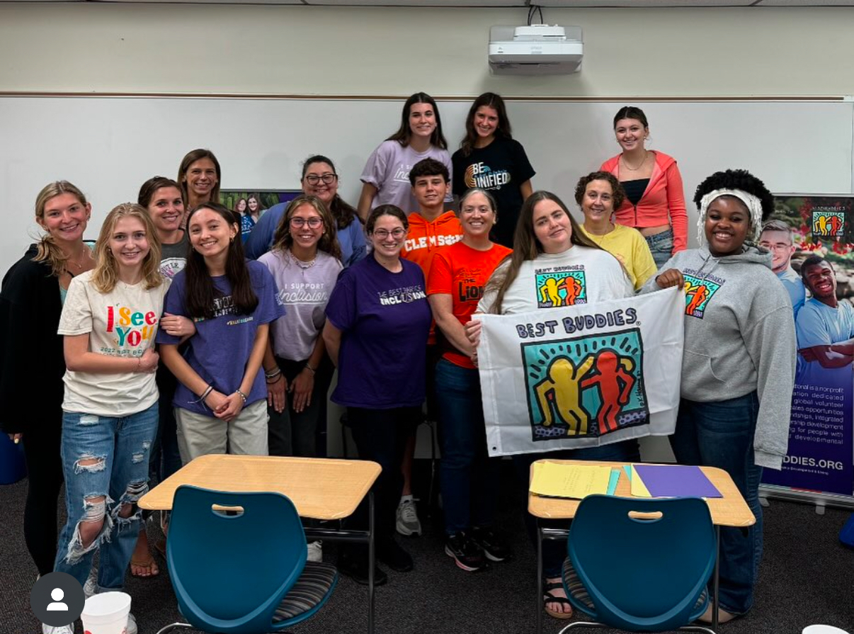 Best Buddies ambassadors posing in front of a classroom.