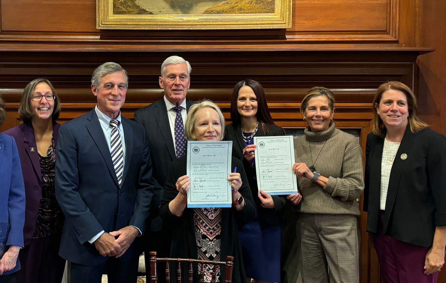 Members of the organization posing for a camera at a legislative bill passing ceremony