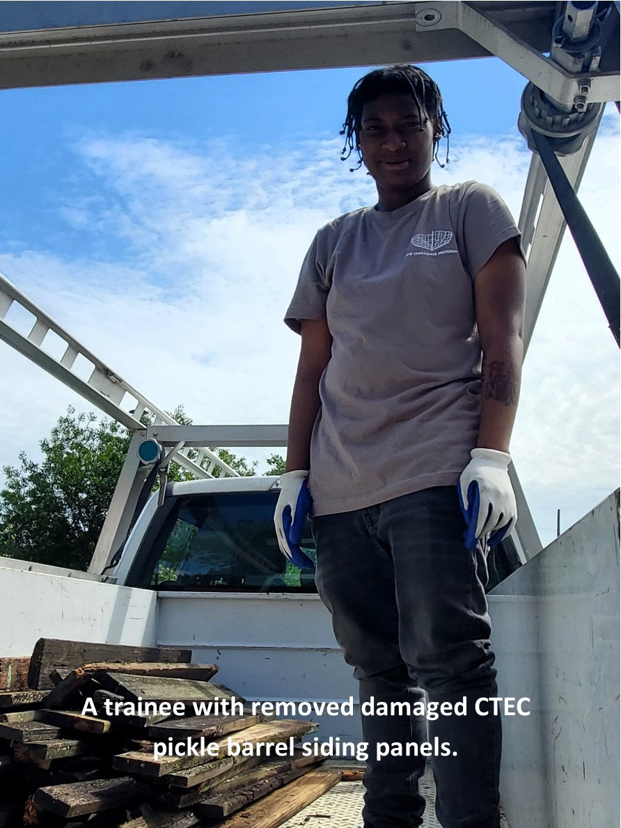 a trainee with removed siding while building new panels.