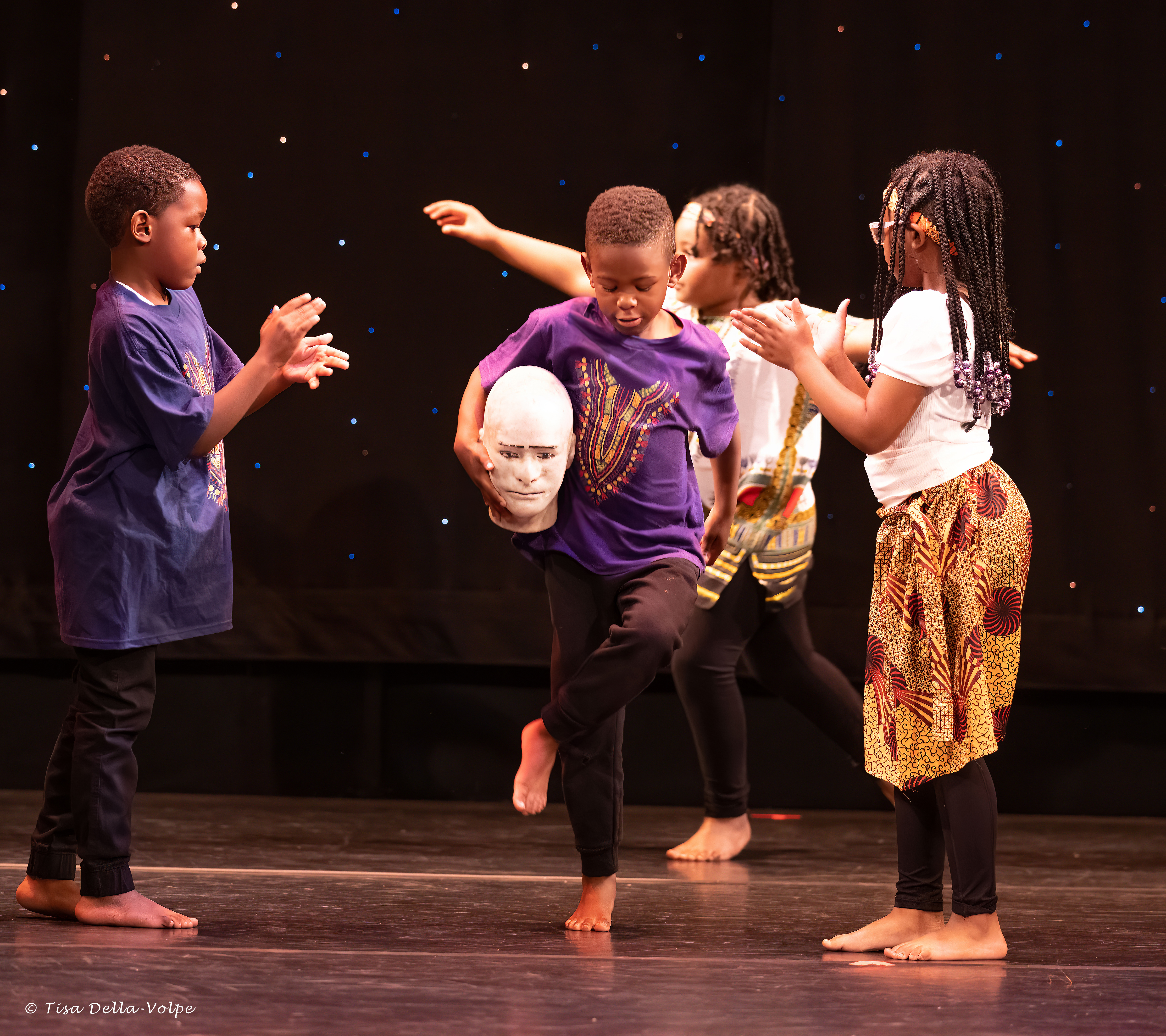 children performing on a stage.