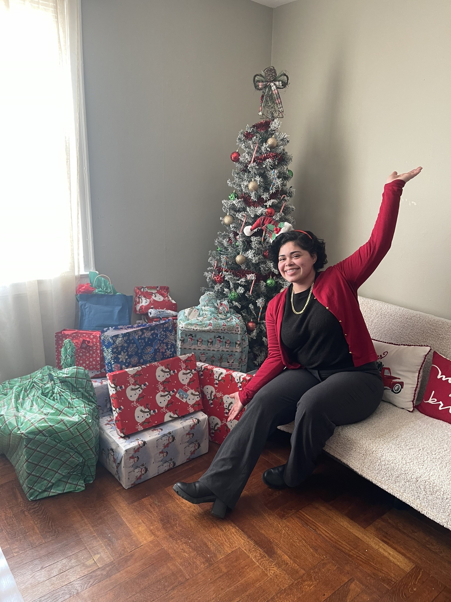 a new homeowner posing inside their home with presents