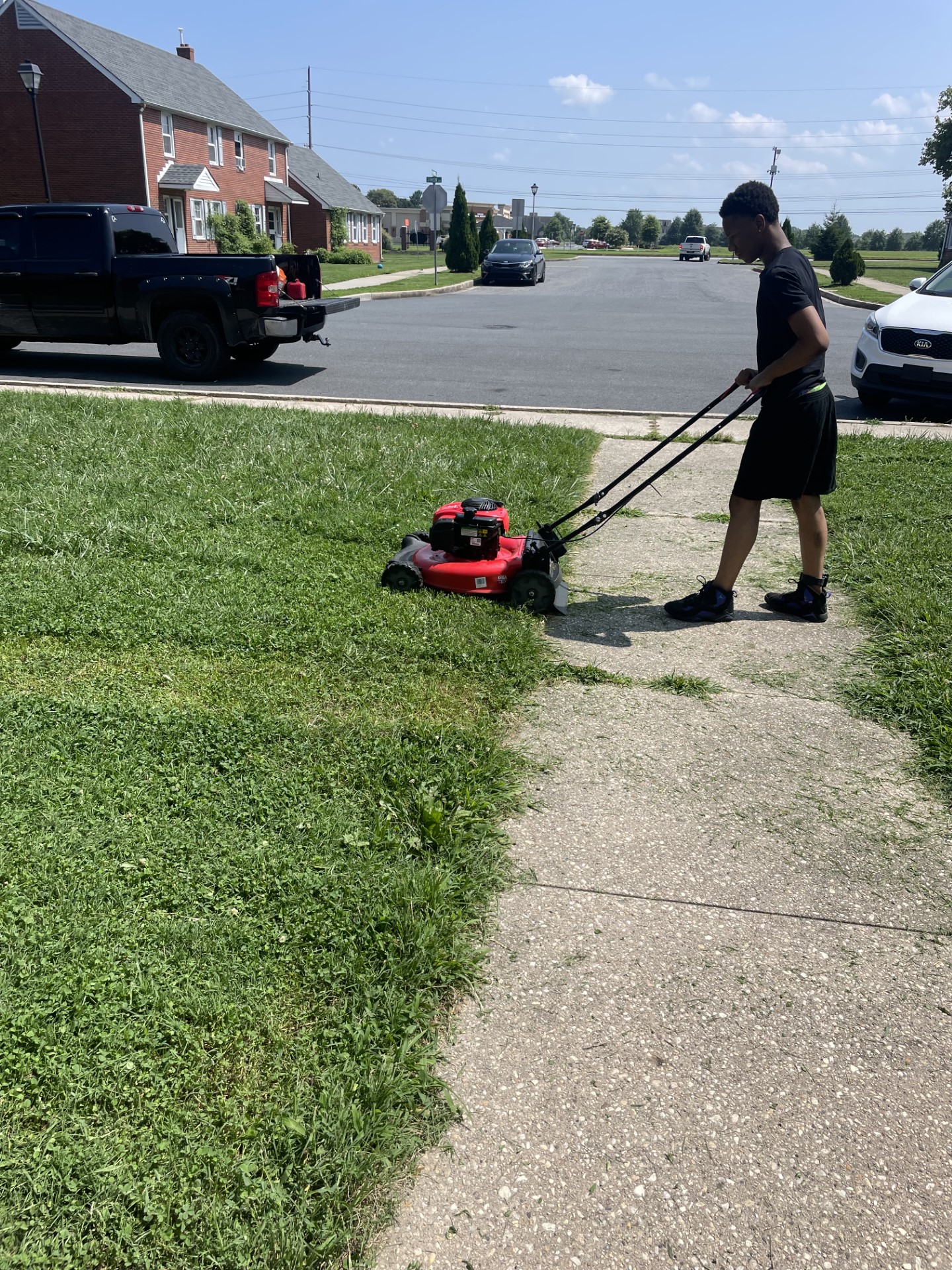 a teen mowing grass while volunteering