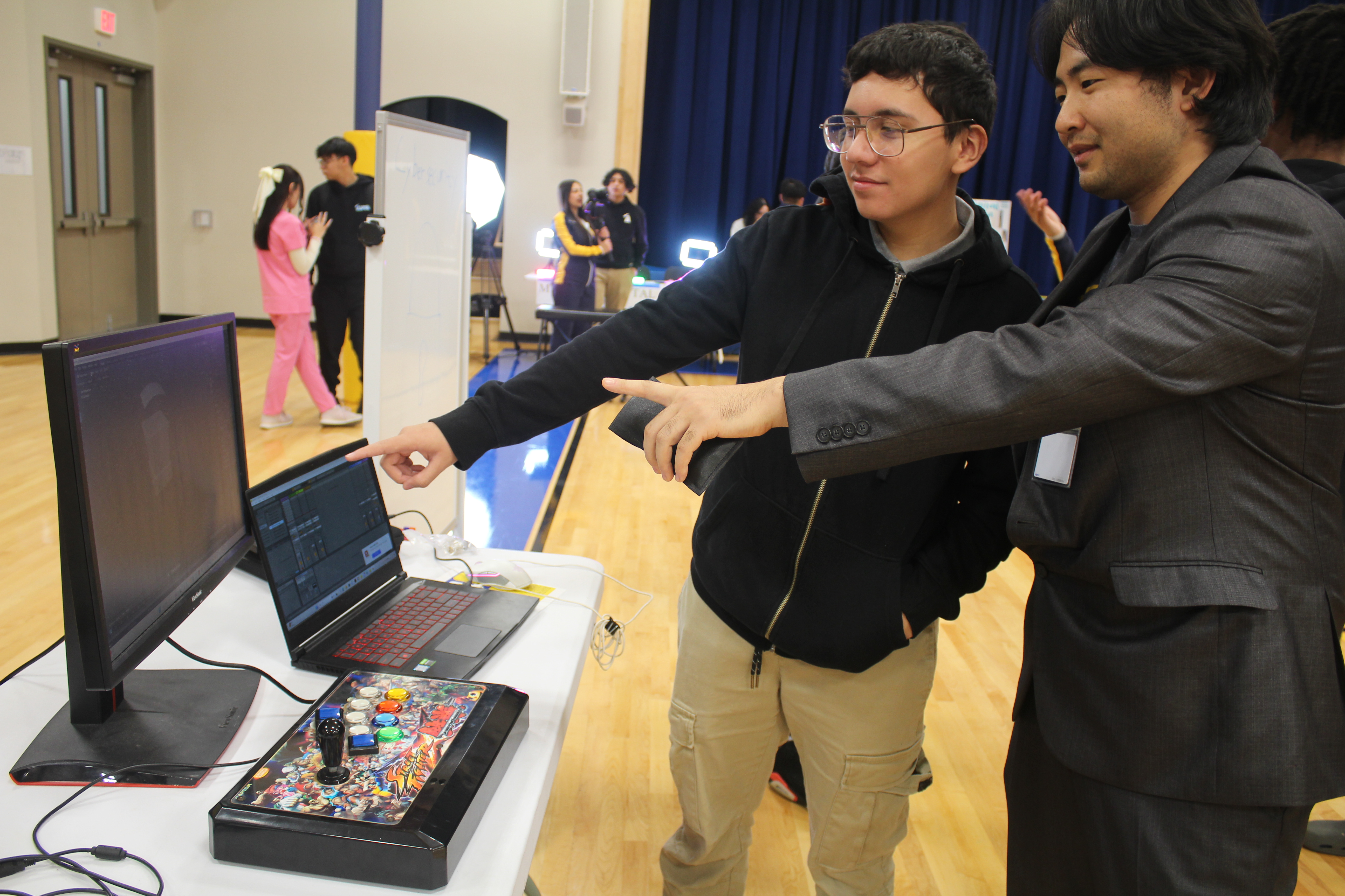a student practicing with a computer game at a career skill fair.