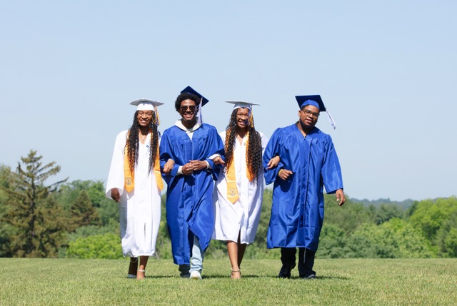 students walking in cap and gown at graduation