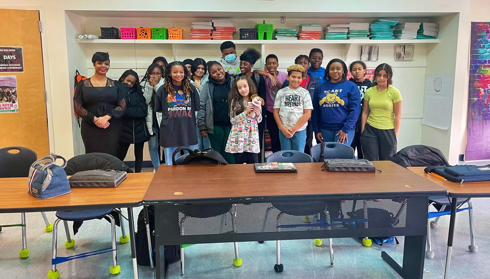 A group of students standing facing the camera alongside two volunteers of the Metropolitan Wilmington Urban League