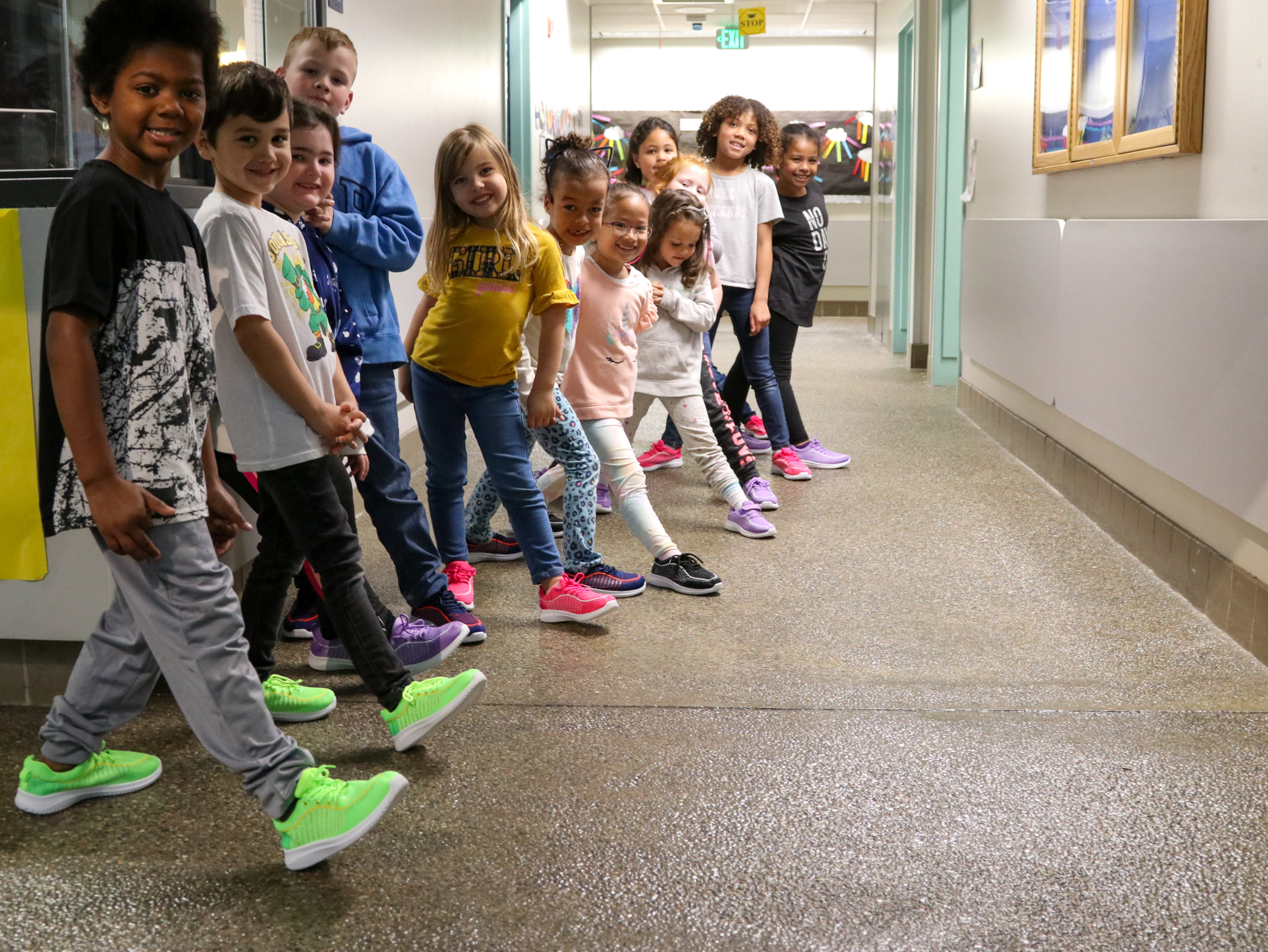 children standing in a hallway smiling