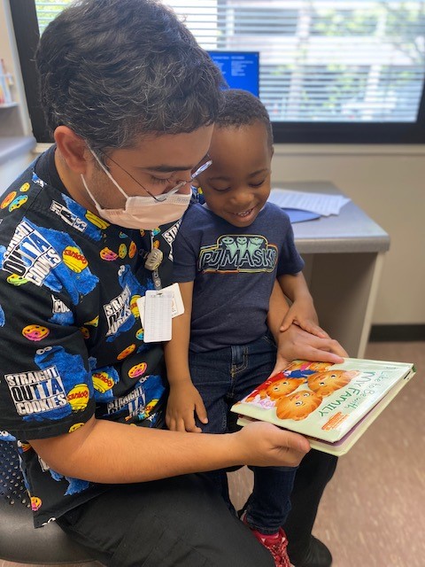 a doctor holding a child while looking at a picture book