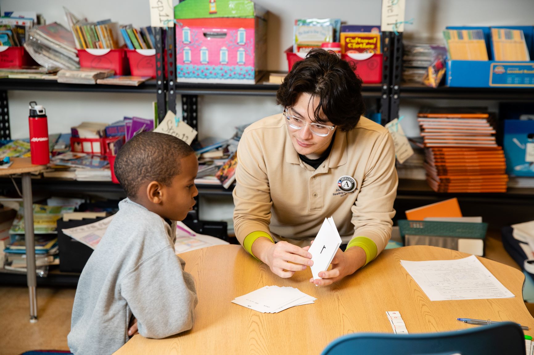 teacher working with a student at a table