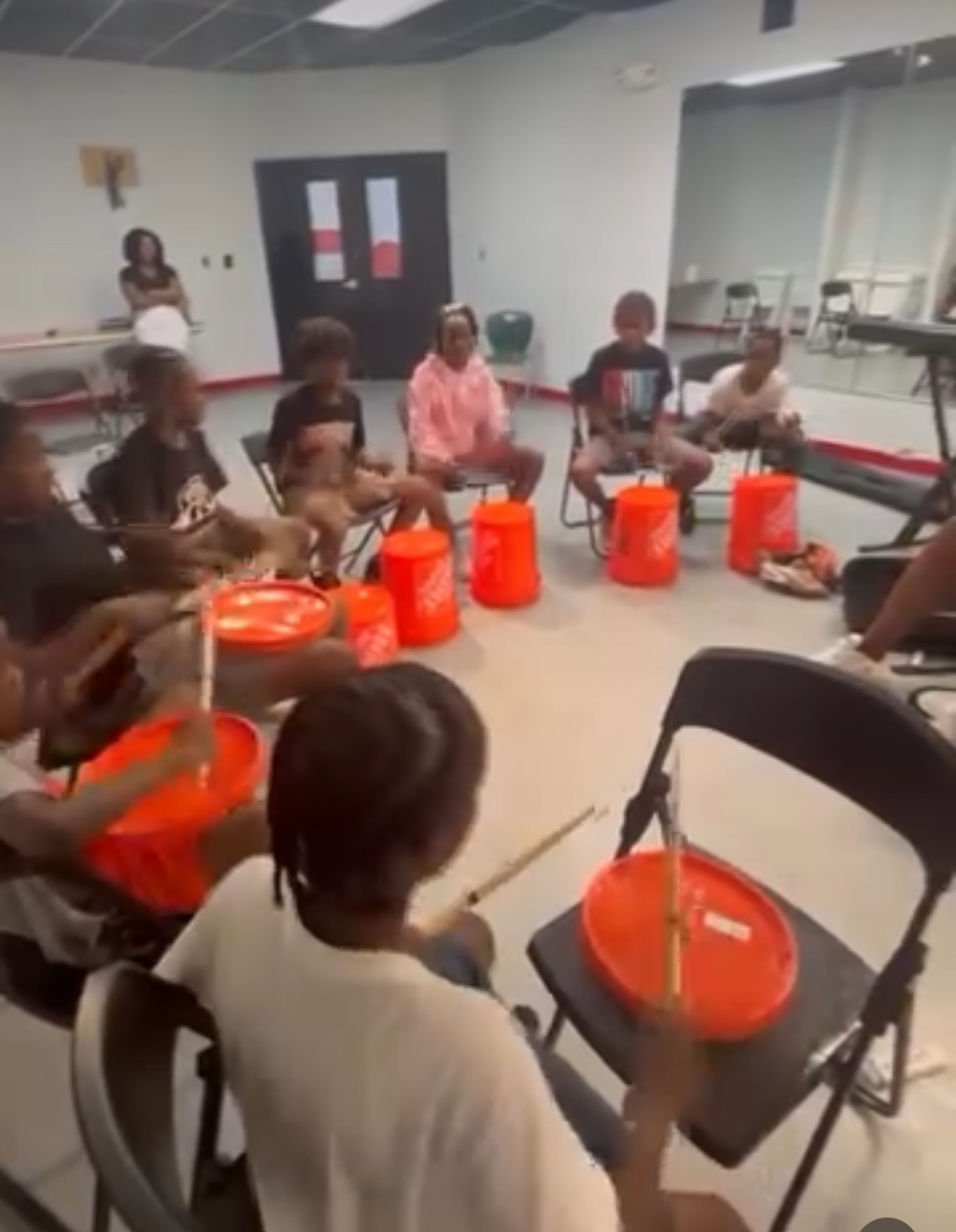 Students participating in a drum class while within the center.