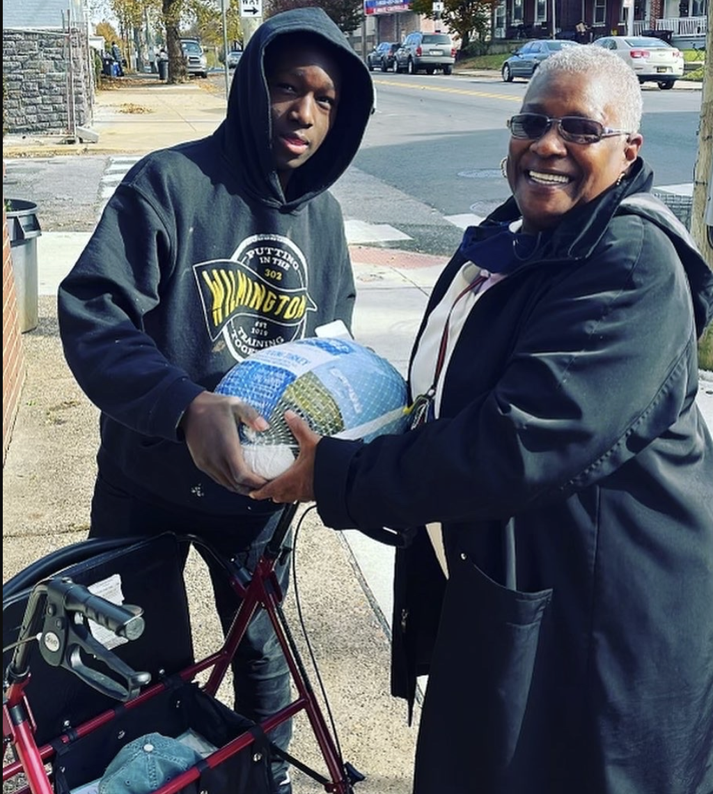 volunteers assisting a person in a thanksgiving drive