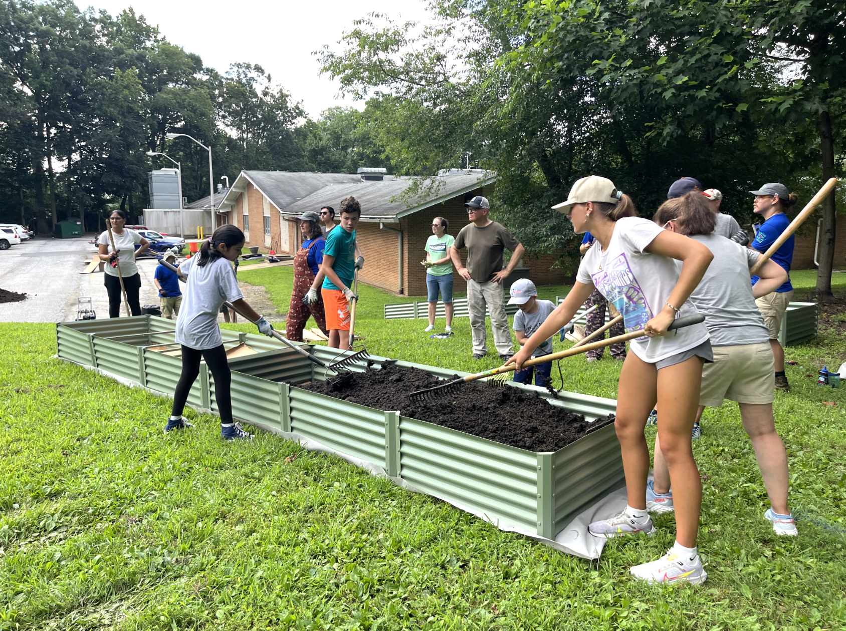 students and instructors working in a garden