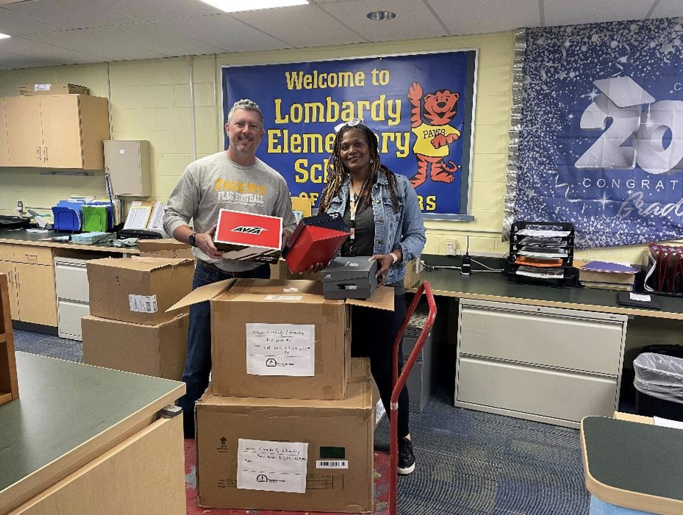 teachers holding sneakers for a distribution program