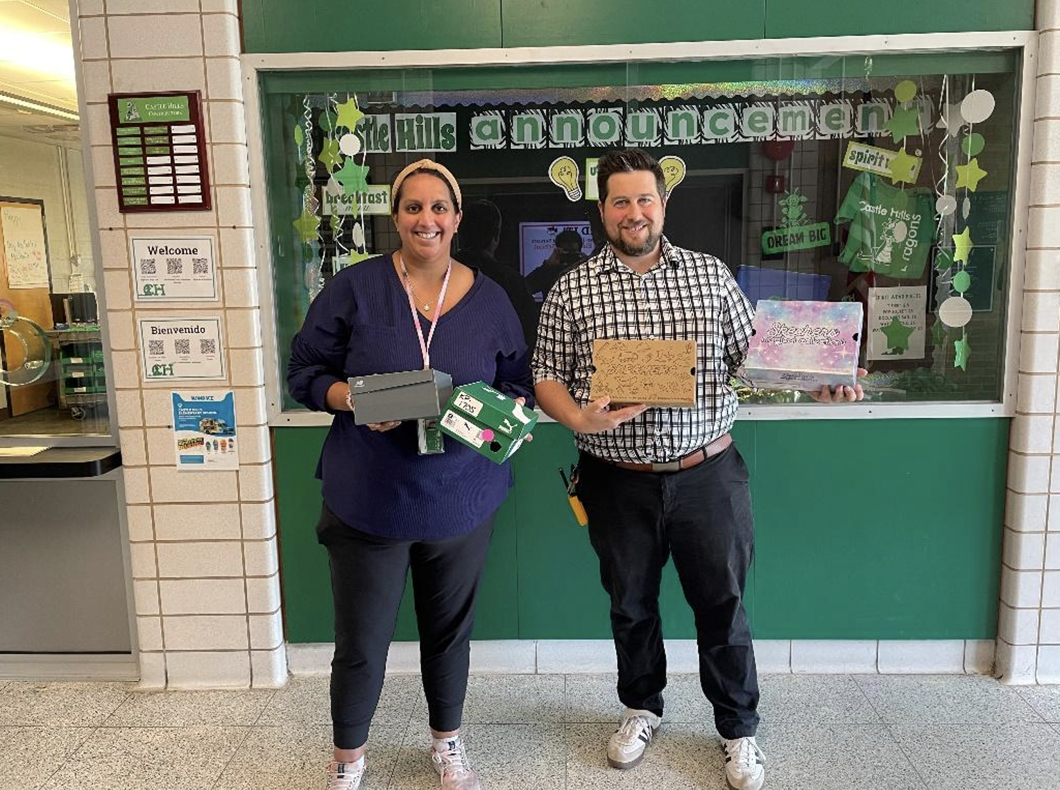 educators holding new sneakers for their students
