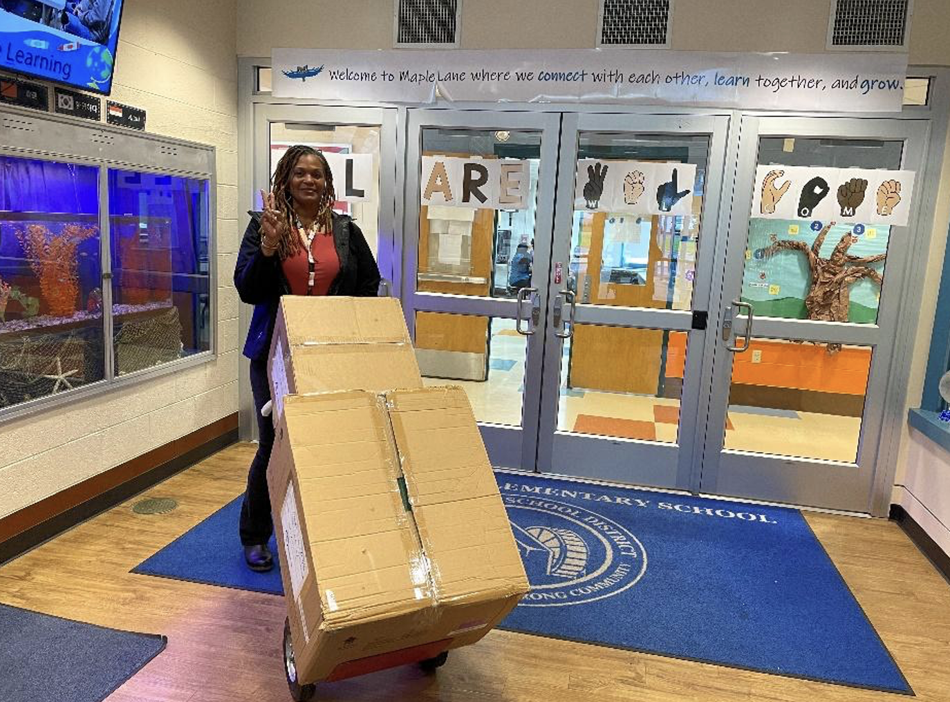 an educator with a freshly donated box of new sneakers for kids