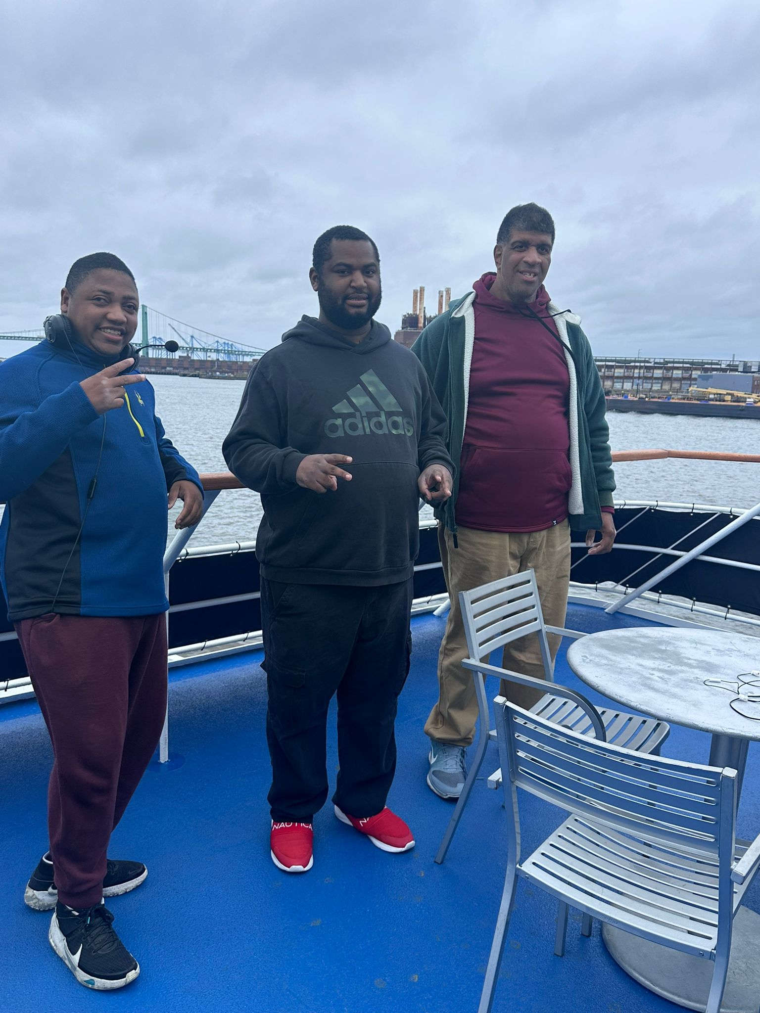 individuals standing at a boat's deck while posing for a photo.