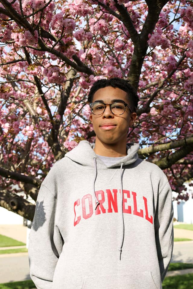 a person posing wearing a Cornell University hoodie