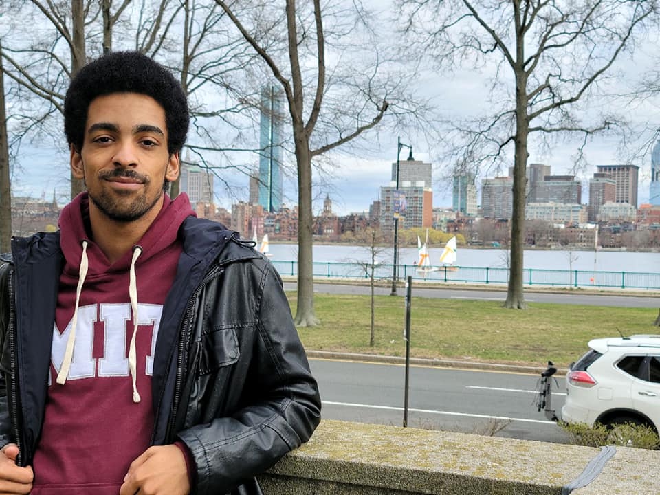 a persons posing outside a patio with an MIT college hoodie on.