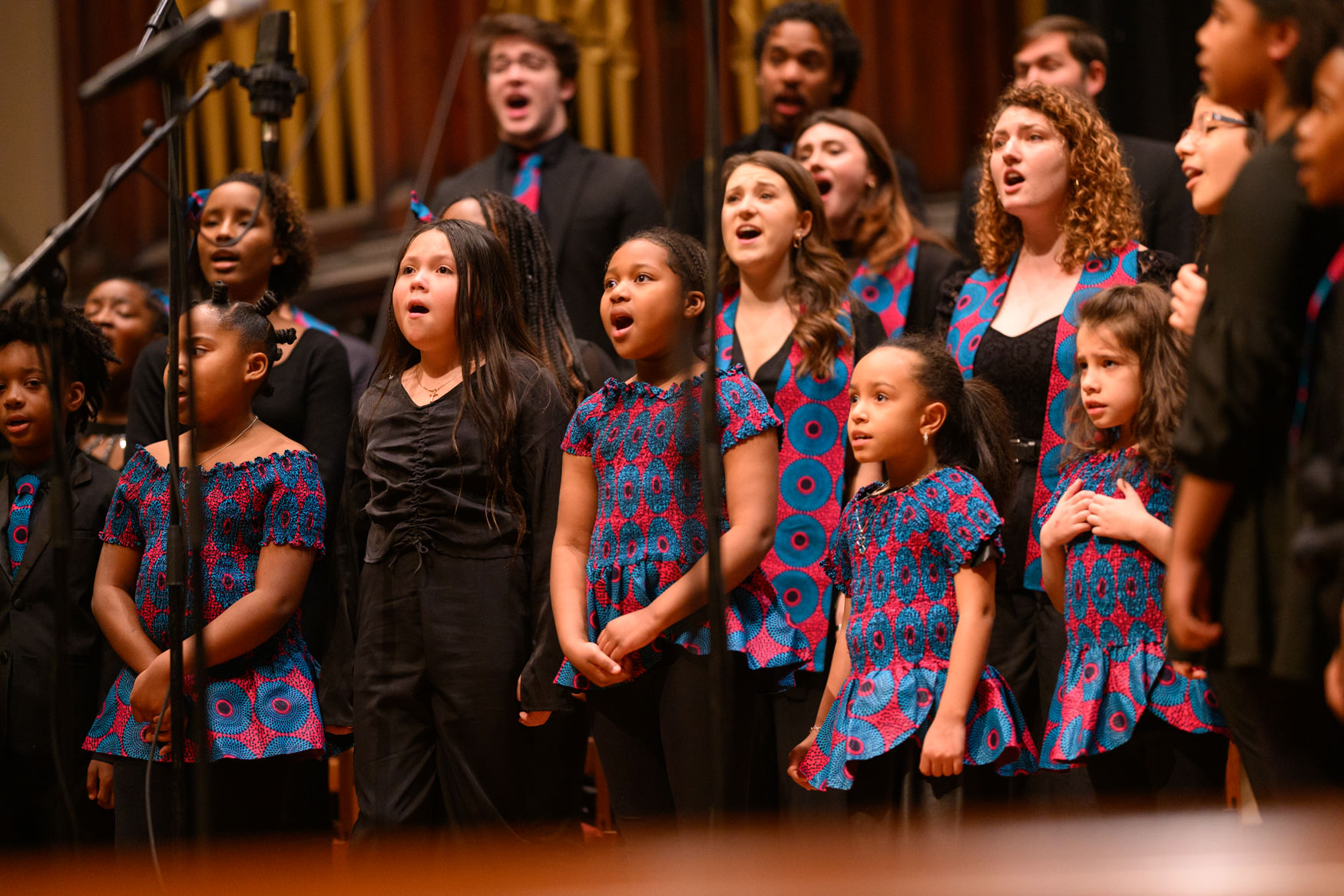 children singing in a chorus on stage.