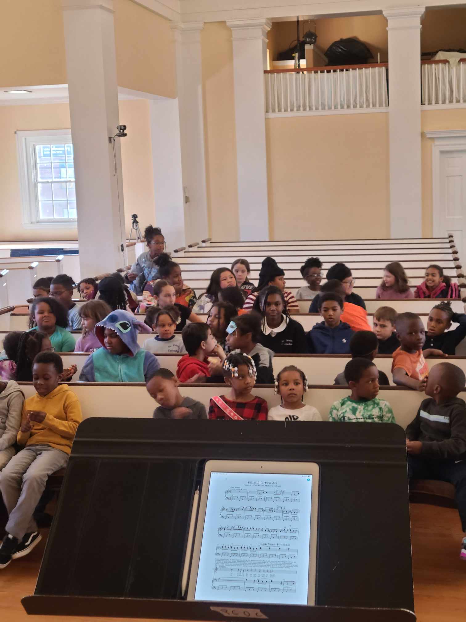 students sit in an auditorium while engaging music programming.