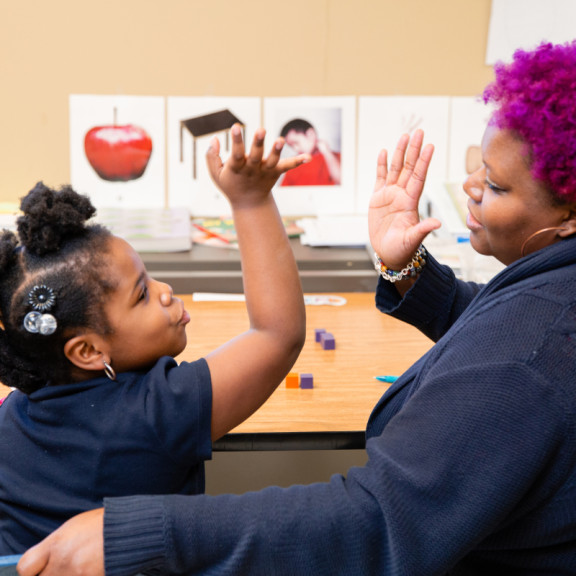 a teacher and student giving high five