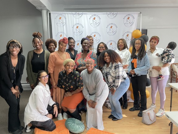 participants at a doula event posing for the camera with children.