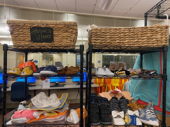 baby shoes and bibs in a donation room of a library.