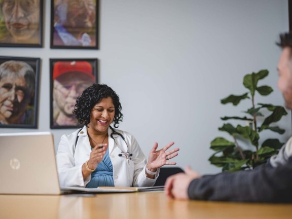 a case worker sitting by a computer helping someone.