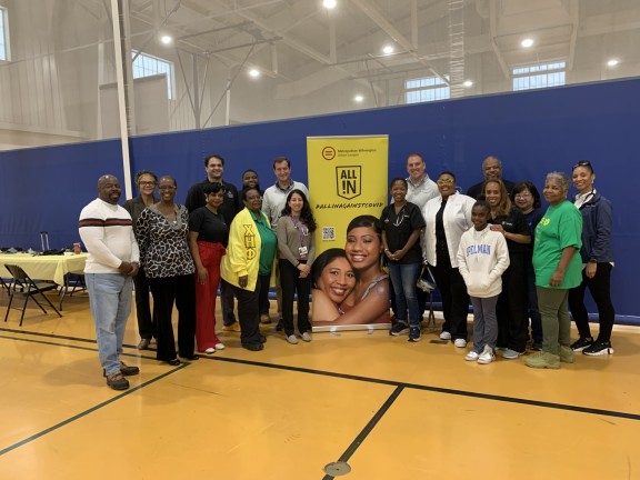 students and adults standing in a gymnasium.