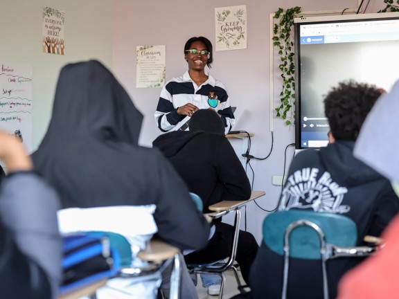 a person at the front of the class with students.