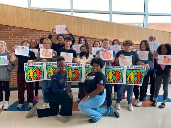 a group of Best Buddies ambassadors posing in a school with youngsters