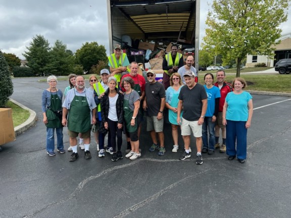 A group of volunteers unloading a truck of donation items