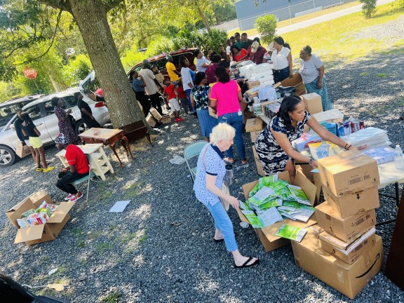 volunteers assist in preparing boxes of donation items for the community.