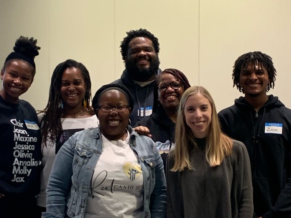 a group of persons pose for a camera while smiling.