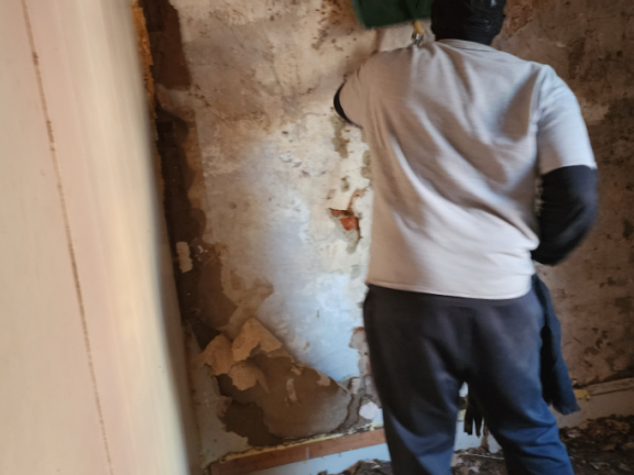 a person remodels the inside of a home building.