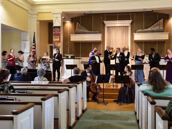 participants in a choir perform to an auditorium of people.