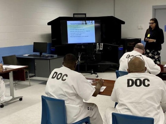 participants in a mental health program sitting in a room.