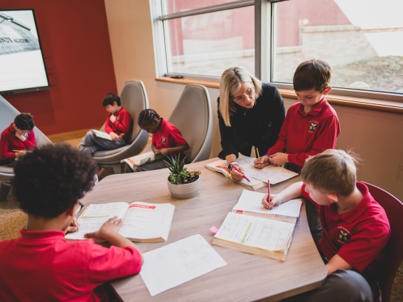 An instructor working with kids in a classroom