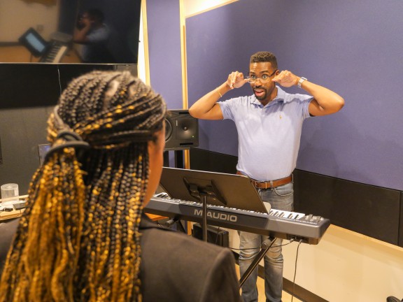 a music instructor and participant rehearsing.