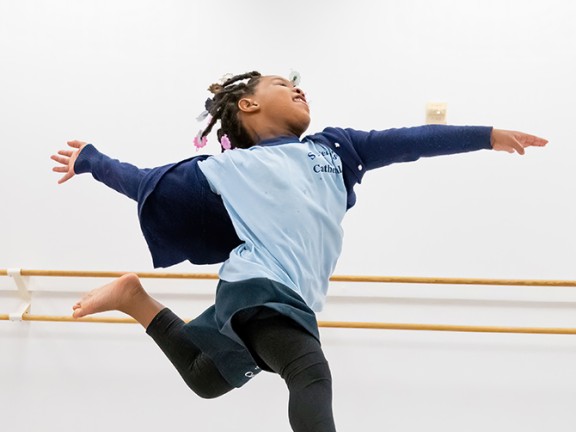 a child dancing in a ballet room.