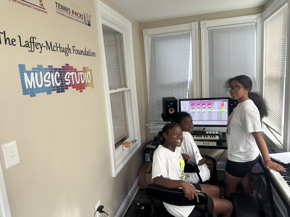 students sitting in a music library room at camp.