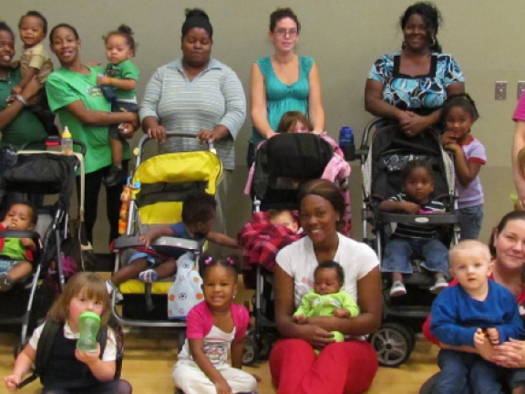 mothers and their children's posing in front of strollers in a community shelter