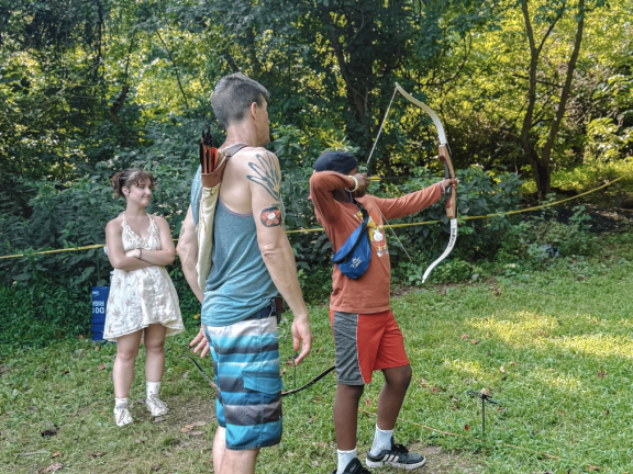 a student and counselor at an archery camp