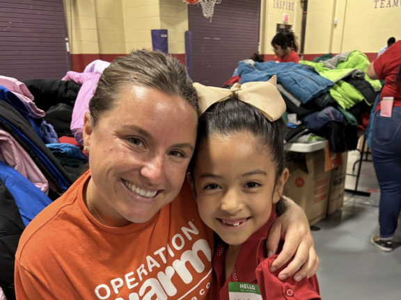 a volunteer distributing coats