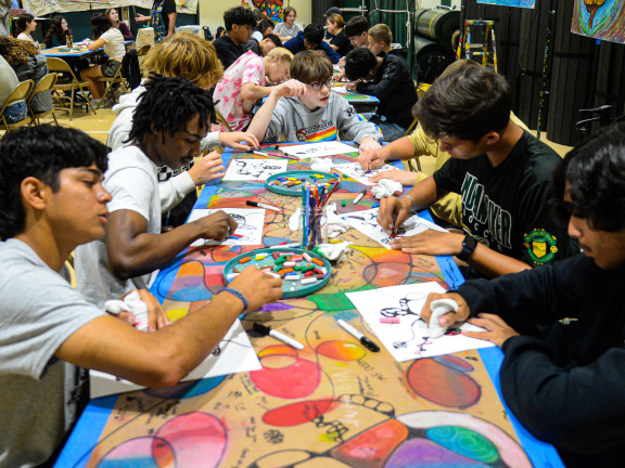 teens painting at a long table