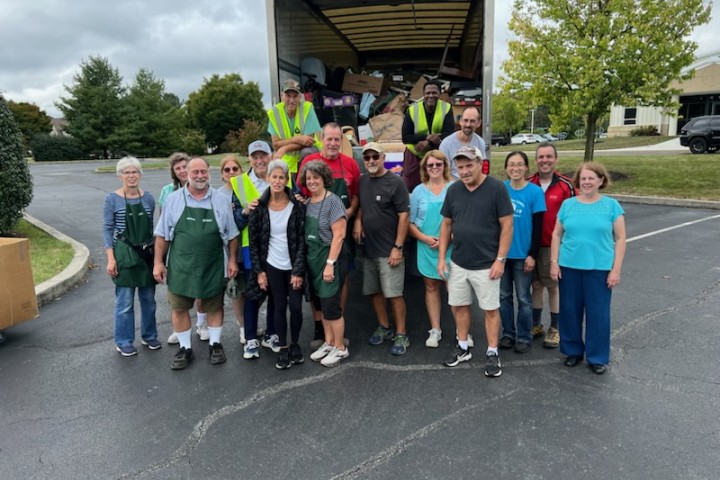 A group of volunteers unloading a truck of donation items