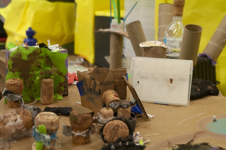 an art display made of papertowel rollers and other arts and crafts sit on a workshop table.