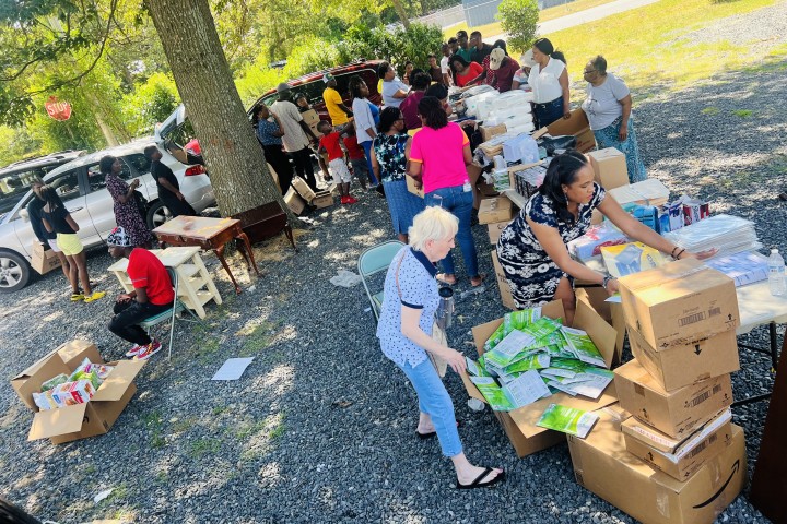 volunteers assist in preparing boxes of donation items for the community.