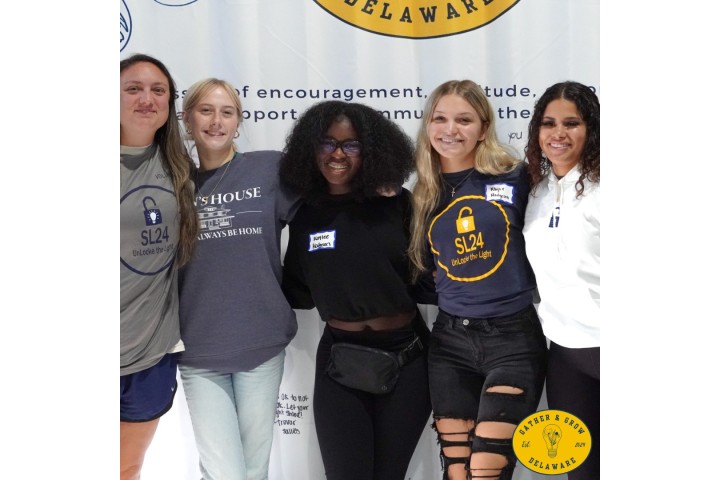 youth posing in front of a wall backdrop while at a mental health summit