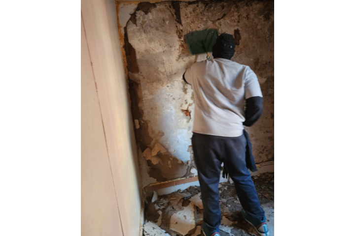 a person remodels the inside of a home building.